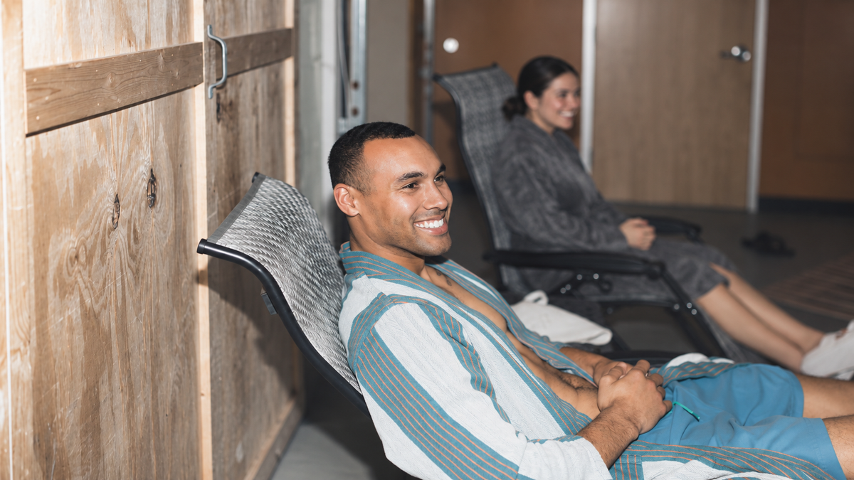 Guests relaxing in chairs between sauna rounds