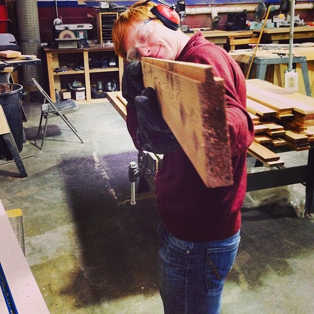 A craftsperson working on a sauna bench in a workshop